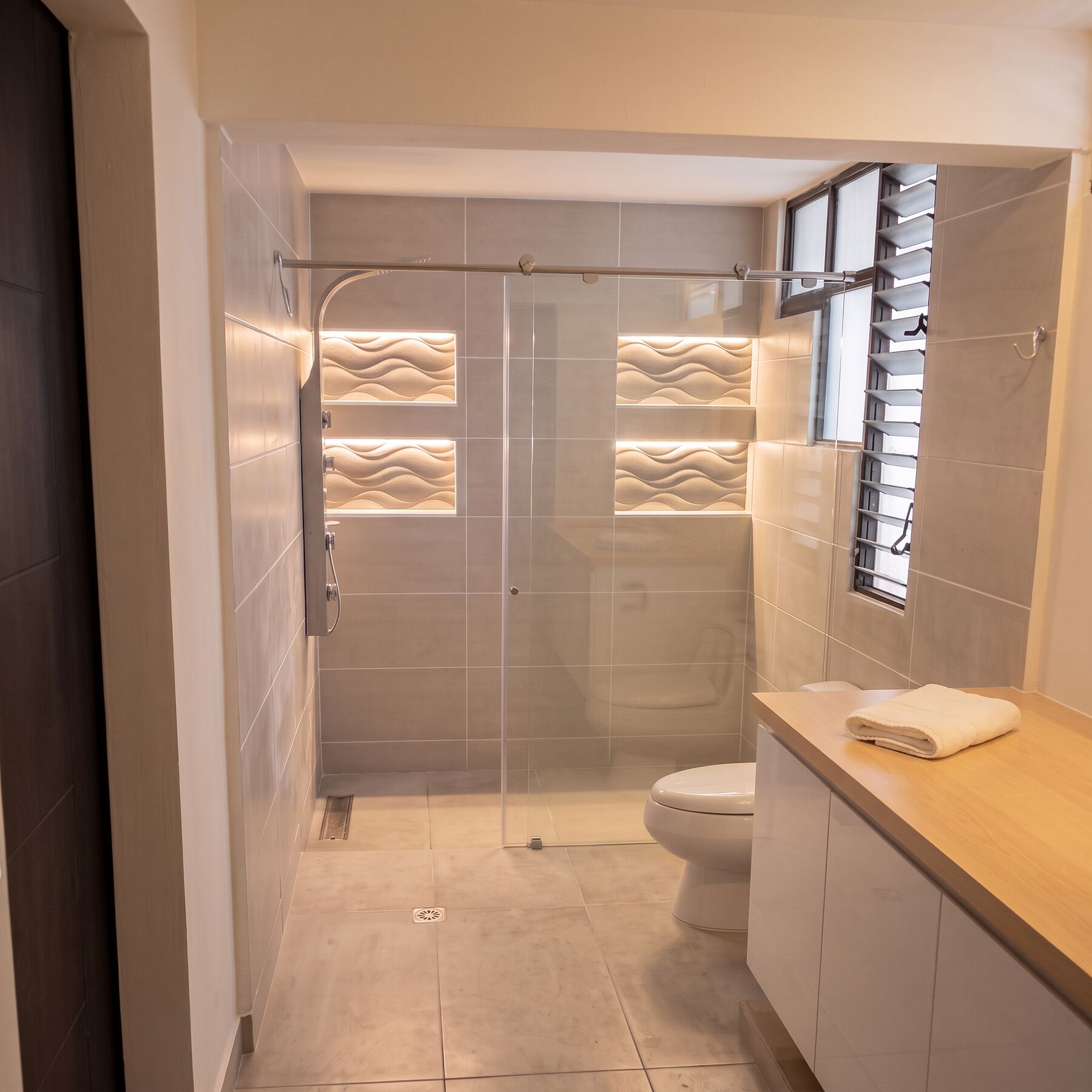 Baño con hornacinas retroiluminadas y mampara de cristal